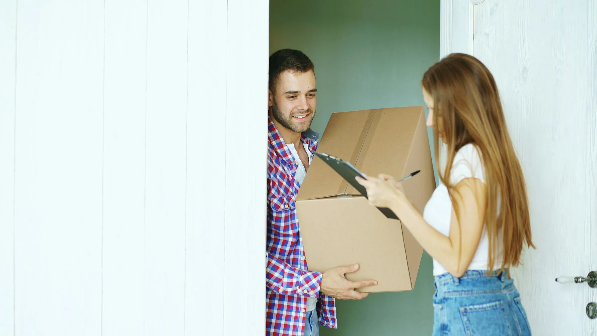 A courier handing a parcel to a customer at their front door